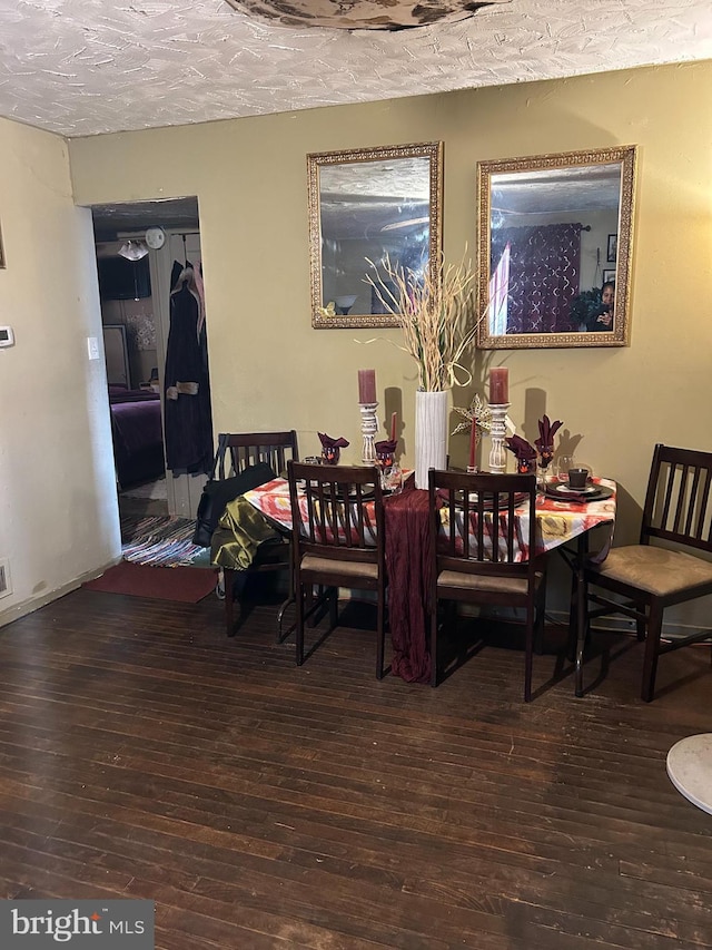 dining area featuring a textured ceiling and dark hardwood / wood-style floors