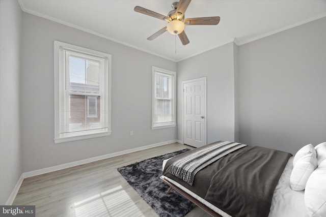 bedroom with light hardwood / wood-style floors, ceiling fan, and ornamental molding