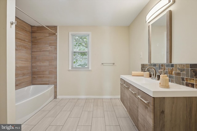 bathroom featuring vanity, tiled shower / bath, and backsplash