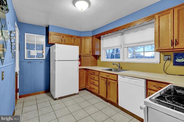 kitchen featuring white appliances, sink, and light tile patterned floors