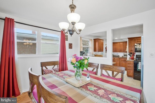 dining room featuring light hardwood / wood-style flooring, an inviting chandelier, and sink