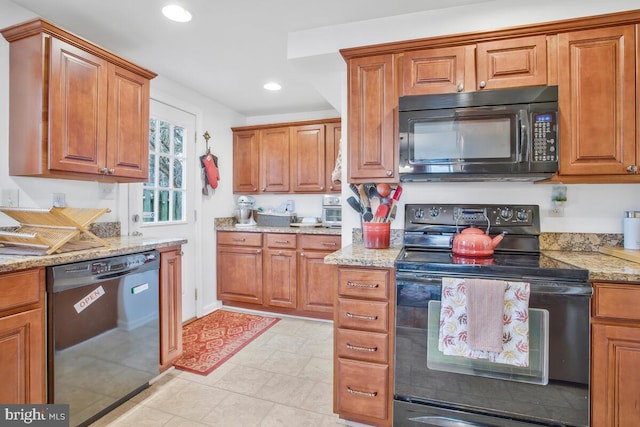 kitchen featuring light stone countertops and black appliances