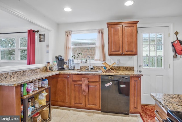 kitchen with light tile patterned floors, black dishwasher, light stone counters, and sink