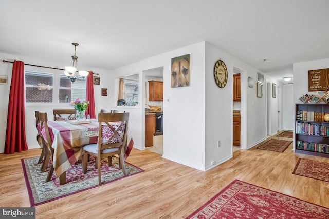 dining area featuring a chandelier and light wood-type flooring