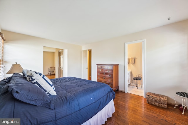 bedroom featuring ensuite bath and dark wood-type flooring