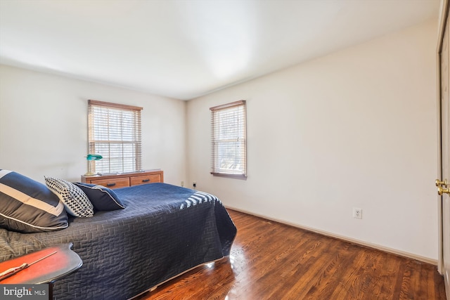 bedroom featuring dark hardwood / wood-style floors and multiple windows