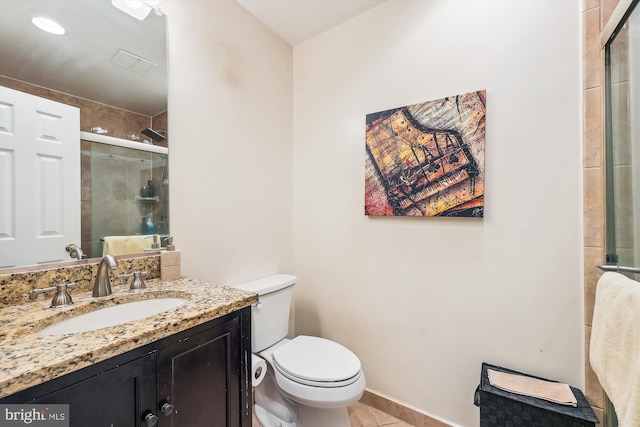 bathroom featuring tile patterned floors, vanity, toilet, and a shower with shower door