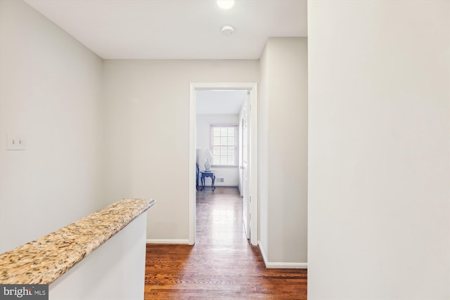 corridor with dark hardwood / wood-style flooring