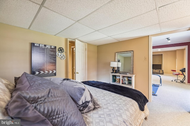 carpeted bedroom with a drop ceiling