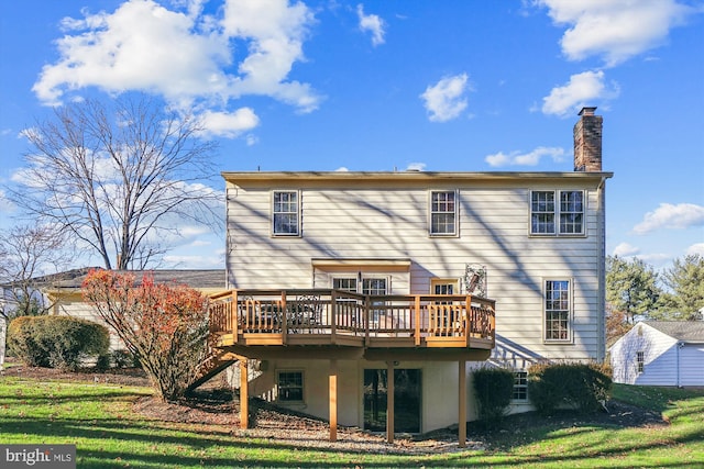 back of property with a yard and a wooden deck