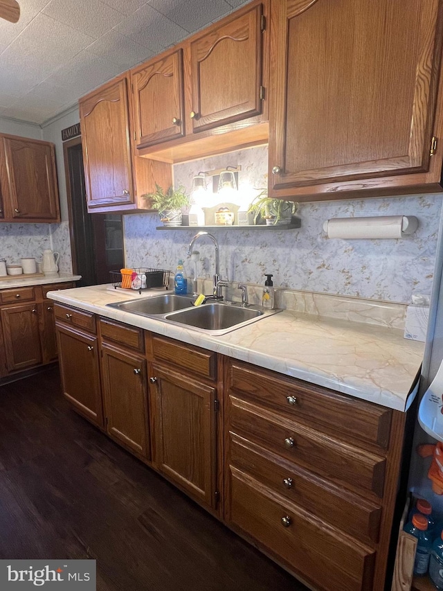 kitchen featuring decorative backsplash, dark wood-type flooring, and sink