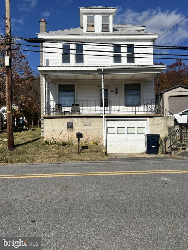 view of front of property featuring covered porch and a garage