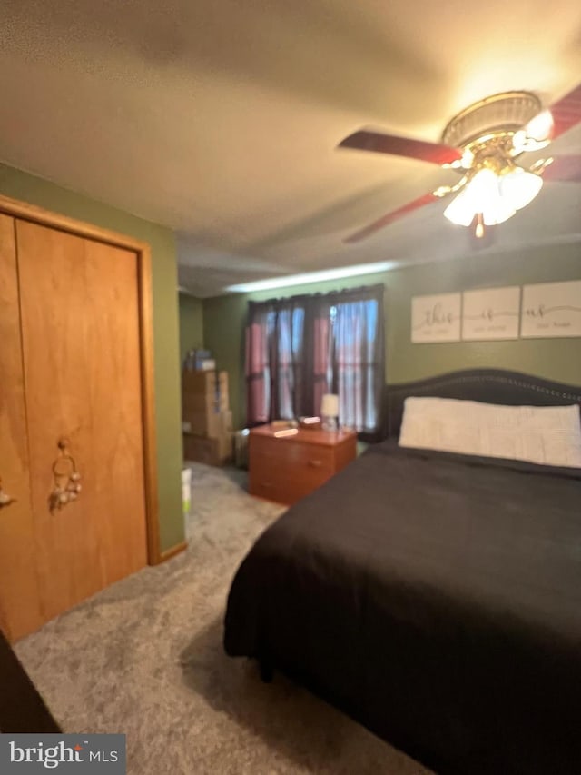 bedroom featuring light colored carpet and ceiling fan