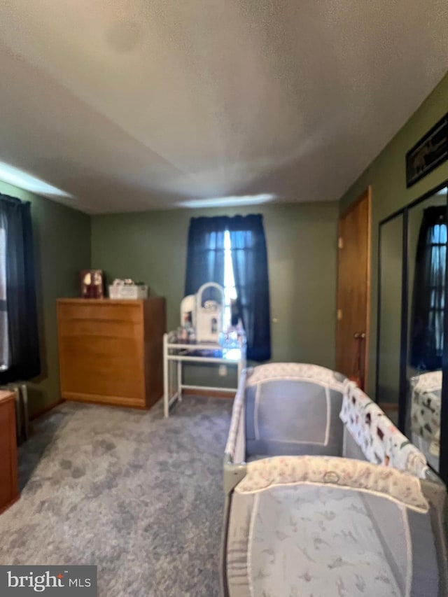 bedroom featuring a closet, light colored carpet, and a textured ceiling