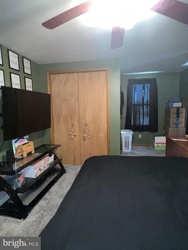 carpeted bedroom with ceiling fan and a closet