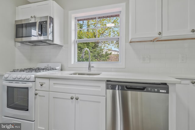 kitchen featuring decorative backsplash, sink, white cabinetry, and stainless steel appliances