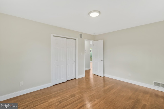 unfurnished bedroom with hardwood / wood-style floors and a closet