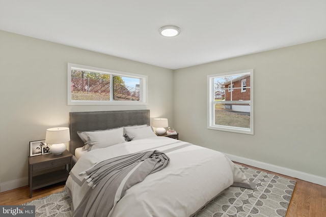 bedroom with wood-type flooring and multiple windows