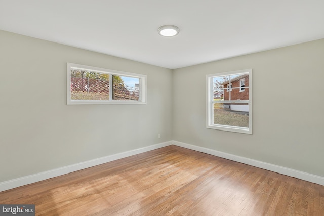 unfurnished room featuring light hardwood / wood-style floors and plenty of natural light