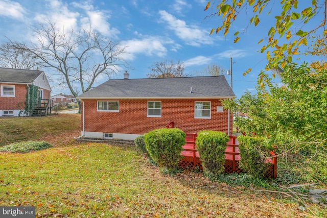 rear view of house featuring a yard and a deck