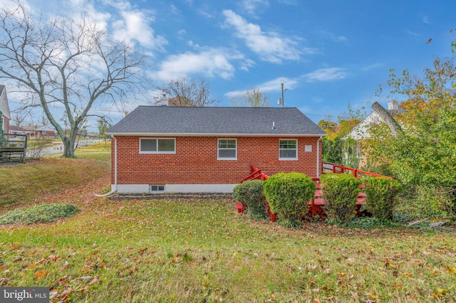 rear view of house featuring a lawn