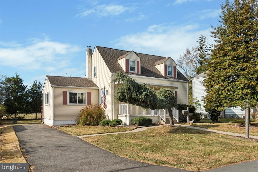 cape cod home featuring a front yard and covered porch