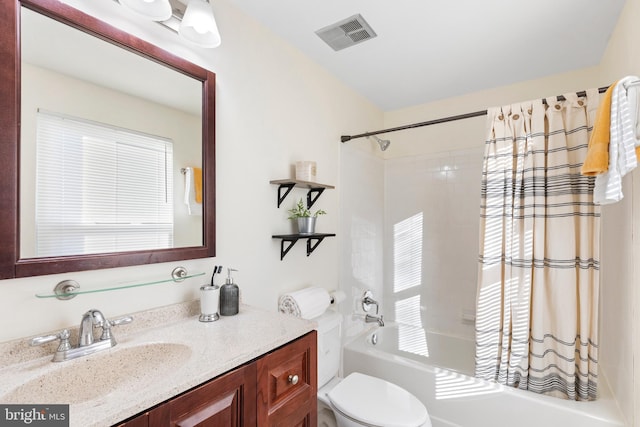 full bathroom featuring vanity, shower / bath combo, and toilet