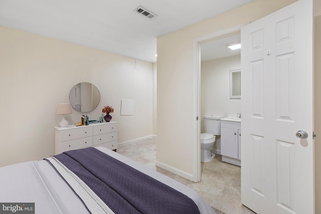 bedroom featuring light tile patterned floors, ensuite bath, and sink