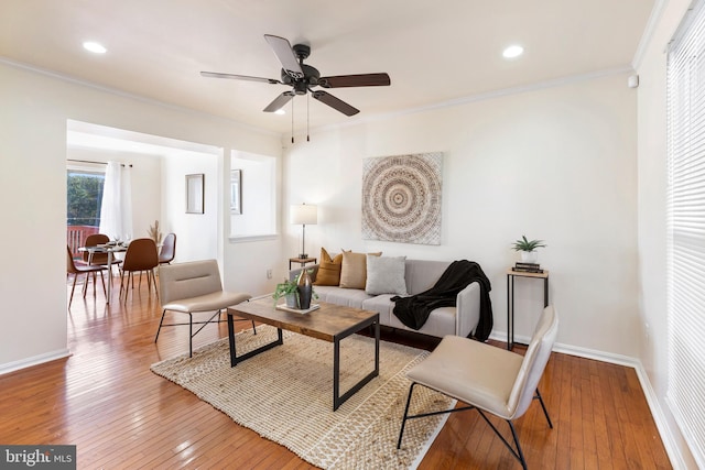 living room with crown molding, ceiling fan, and hardwood / wood-style flooring