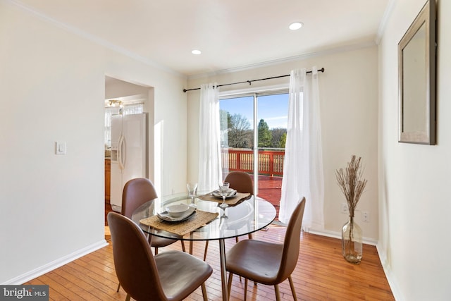 dining room featuring crown molding and light hardwood / wood-style floors