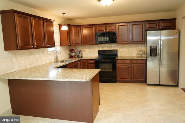 kitchen featuring kitchen peninsula, light stone countertops, sink, black appliances, and hanging light fixtures