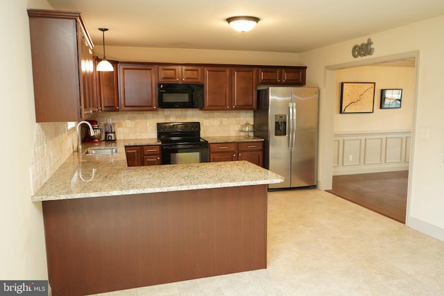 kitchen featuring black appliances, pendant lighting, kitchen peninsula, and sink