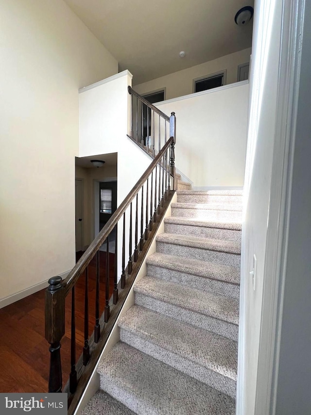 staircase with hardwood / wood-style floors