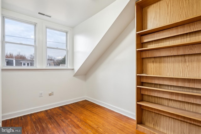 additional living space with hardwood / wood-style floors