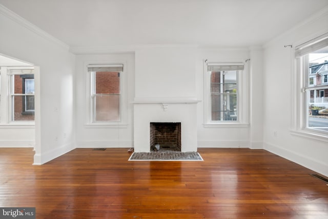 unfurnished living room featuring ornamental molding, dark hardwood / wood-style floors, and a brick fireplace