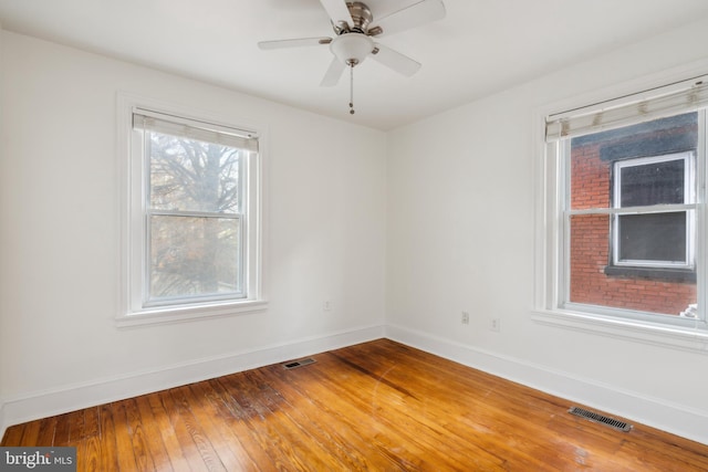 empty room with ceiling fan and hardwood / wood-style flooring