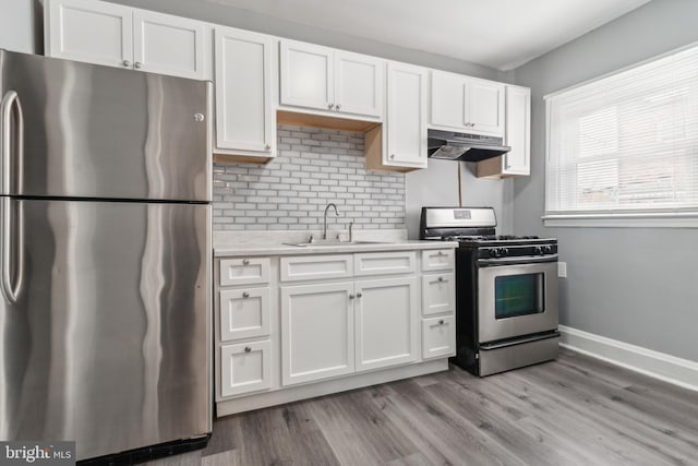 kitchen with white cabinets, sink, light wood-type flooring, and stainless steel appliances