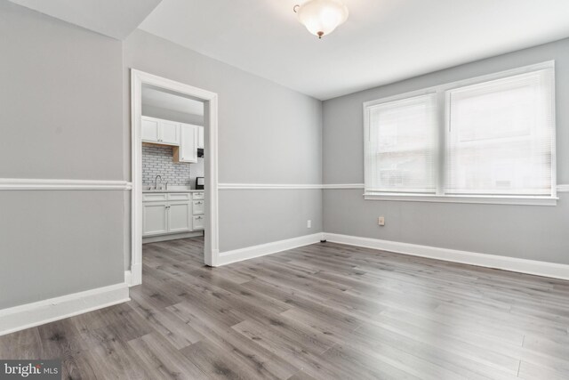 unfurnished room with light wood-type flooring and sink