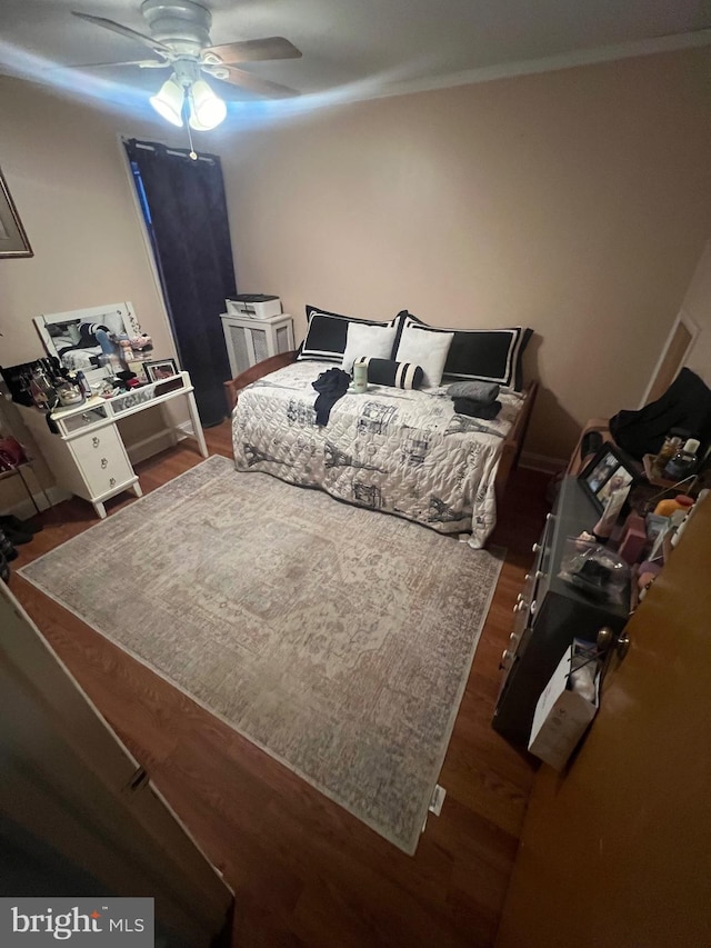 bedroom featuring ceiling fan and dark wood-type flooring