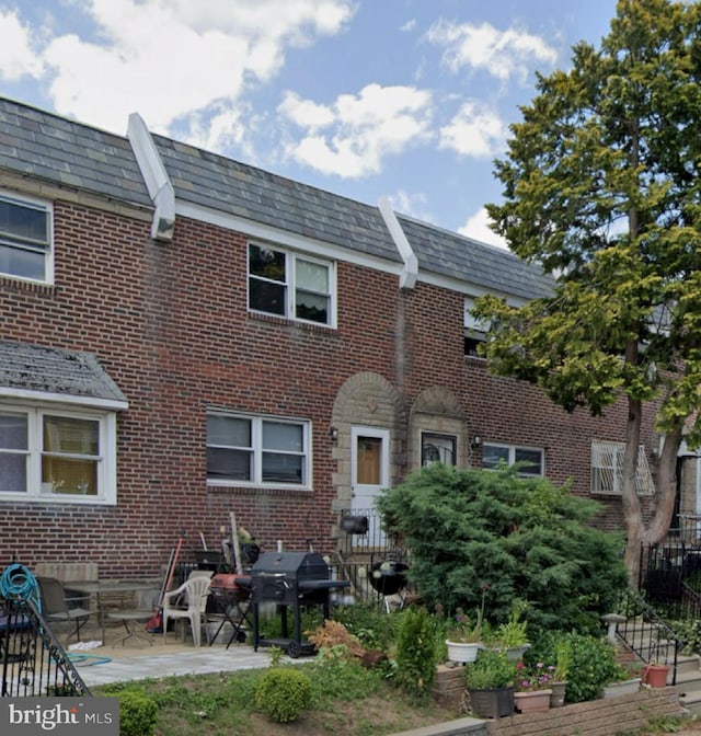 6412 Akron St, Philadelphia, PA 19149 - rear view of property featuring a high end roof, brick siding, and a patio area