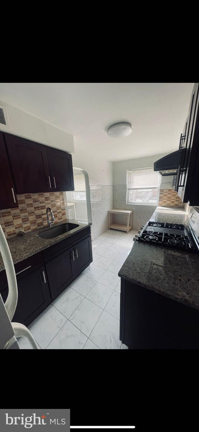 6412 Akron St, Philadelphia, PA 19149 - kitchen with a sink, range, backsplash, and dark cabinets