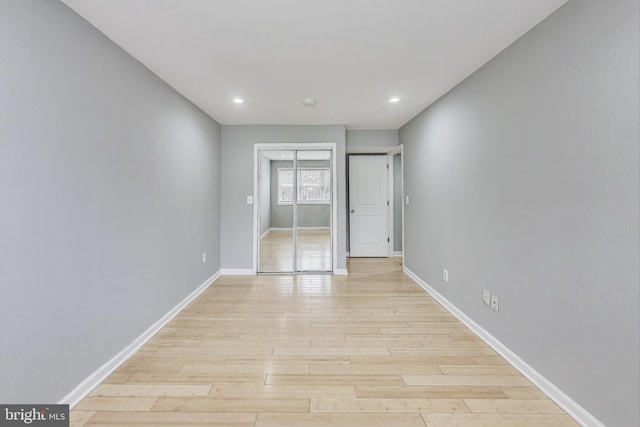 unfurnished bedroom with light wood-type flooring and a closet