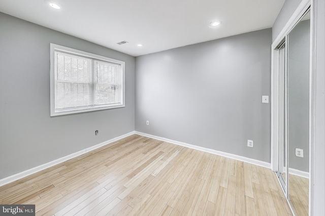 unfurnished bedroom featuring light hardwood / wood-style floors and a closet