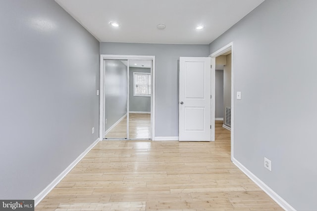 unfurnished bedroom with a closet and light wood-type flooring