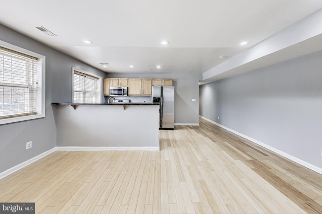 5045 Call Pl SE Unit 102, Washington, DC 20019 - kitchen with appliances with stainless steel finishes, dark countertops, a peninsula, light wood-style floors, and recessed lighting
