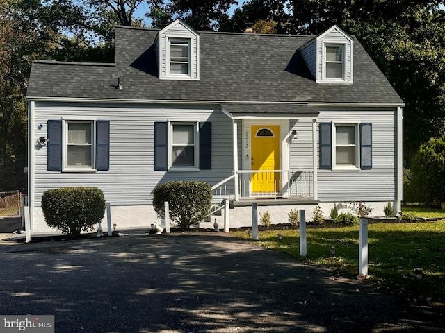 cape cod-style house featuring a front lawn