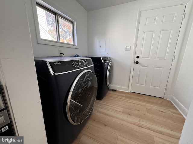 laundry room featuring washer and clothes dryer and light hardwood / wood-style floors