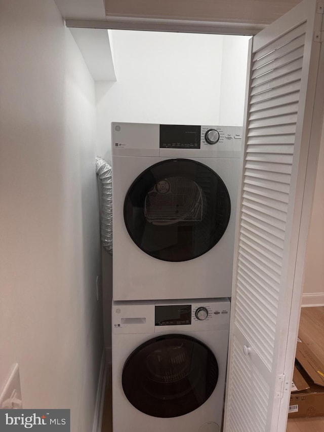 laundry room with stacked washer / dryer