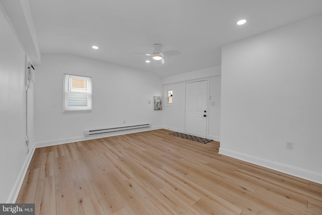 unfurnished room featuring ceiling fan, light wood-type flooring, and a baseboard heating unit