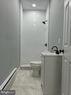 bathroom featuring vanity, toilet, walk in shower, and a baseboard heating unit